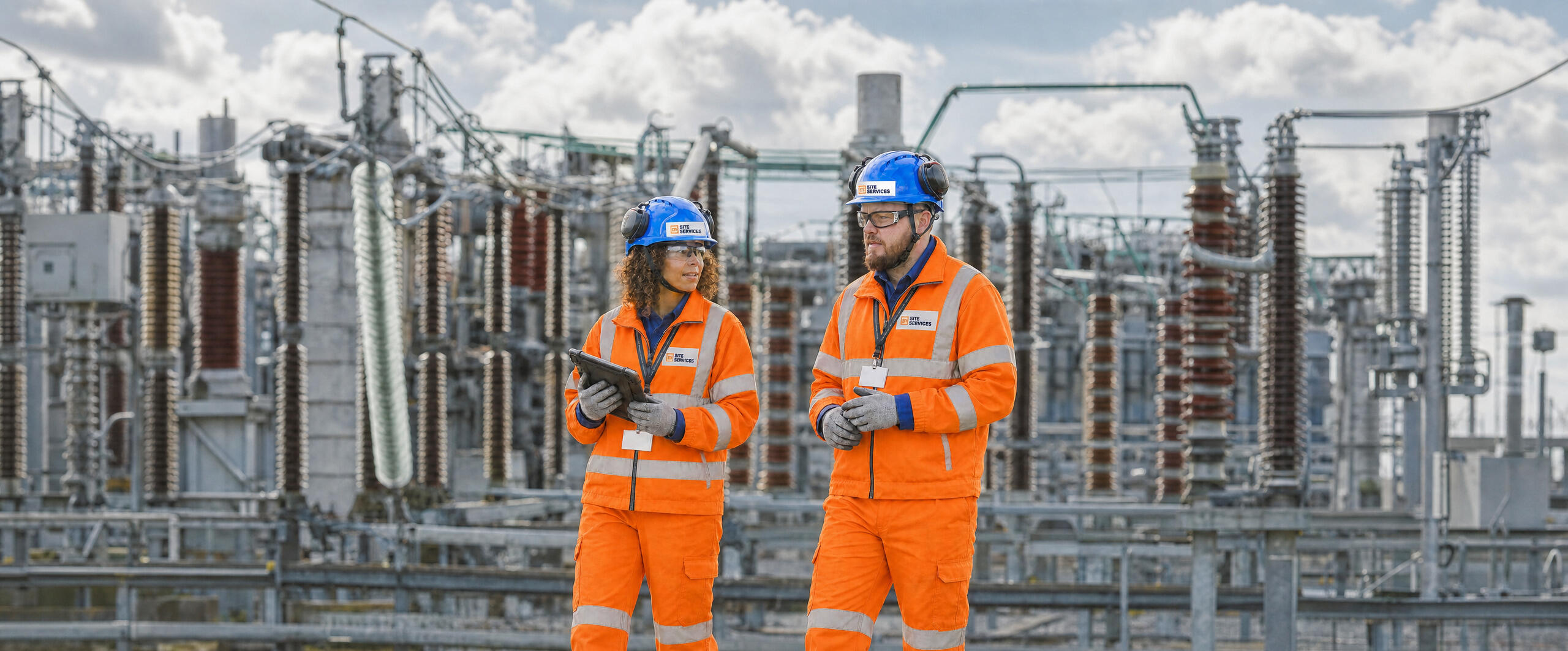 Woman and man in PPE gear on site.